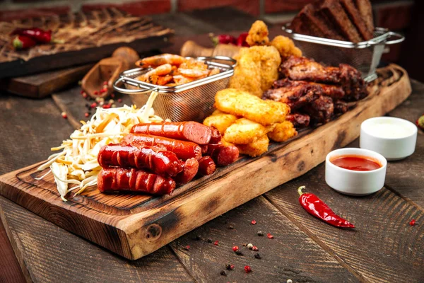 Snacks de cerveza frita en el tablero de madera con salsas — Foto de Stock