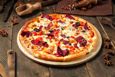 Pizzanın yanında füme et ve sebze.