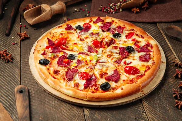 Pizzanın yanında füme et ve sebze.