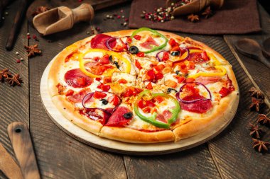 Tahta masada salamlı ve dolmalık biberli pizza.