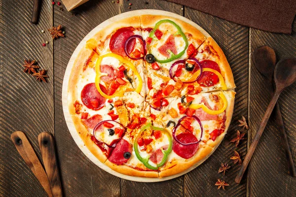 Tahta masada salamlı ve dolmalık biberli pizza.