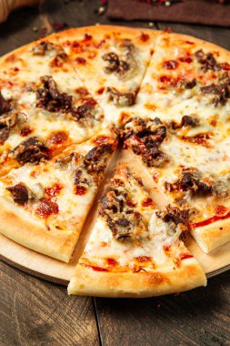 Peynirin altında et ve dilimlenmiş pizza. 