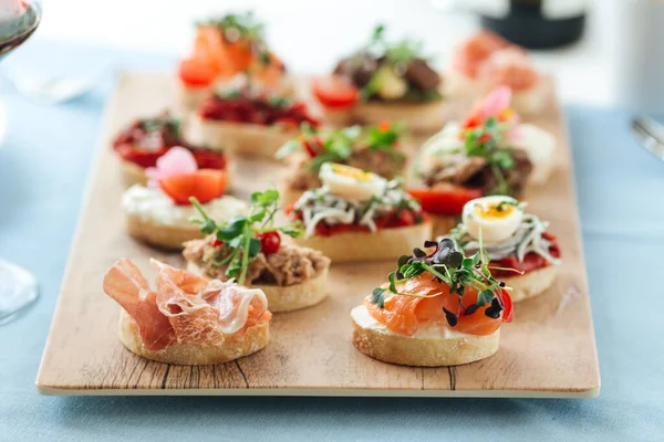 Side view on assorted tapas with different toppings — Stock Photo, Image