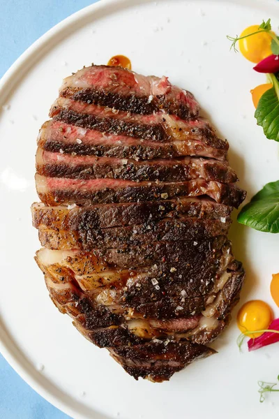 Beyaz tabakta dilimlenmiş biftek. — Stok fotoğraf