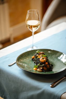 Deniz ürünleri ve safran soslu siyah spagetti.