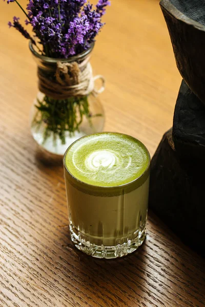 Bebida verde matcha en vidrio sobre la mesa de madera — Foto de Stock