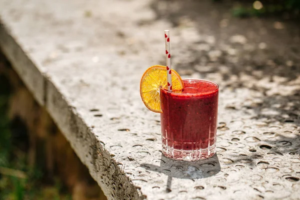 Smoothie aux baies rouges dans un verre avec une paille — Photo