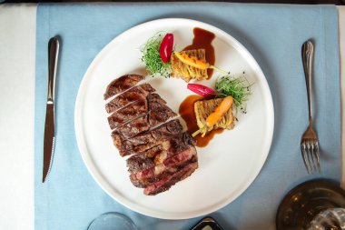 Kızarmış bifteği patatesle kes.