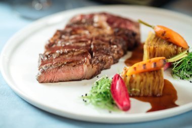 Kızarmış bifteği patatesle kes.