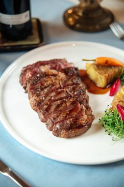 Kızarmış bifteği patatesle kes.