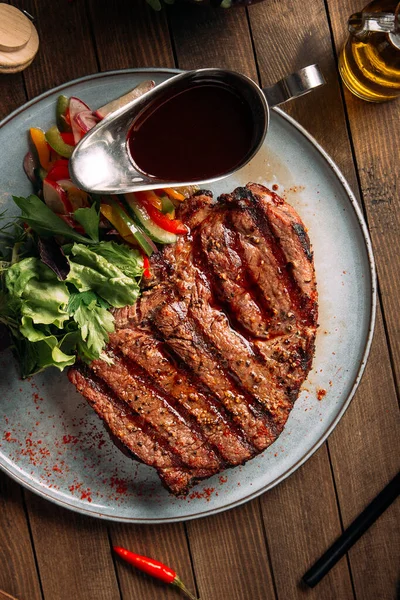 Vista superior em bife grelhado com verduras e molho — Fotografia de Stock