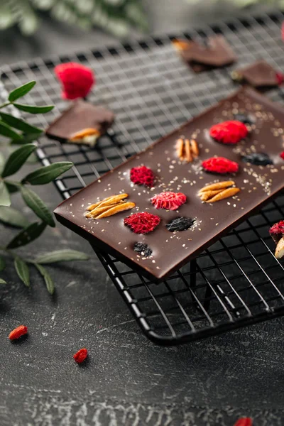 Handmade chocolate bar with pecan nuts and berries