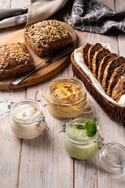 Farklı sosları dilimlenmiş ekmekle kavanozlara yaymak.