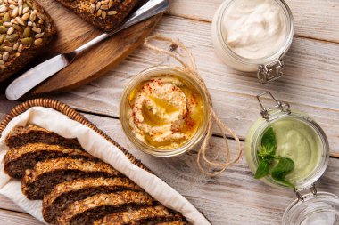 Farklı sosları dilimlenmiş ekmekle kavanozlara yaymak.