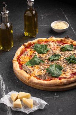 Ispanak yapraklı ve siyah taşlı peynirli sıcak kıymalı pizza.