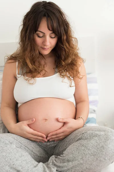 Feliz Mujer Embarazada Sentada Tocando Vientre Casa —  Fotos de Stock