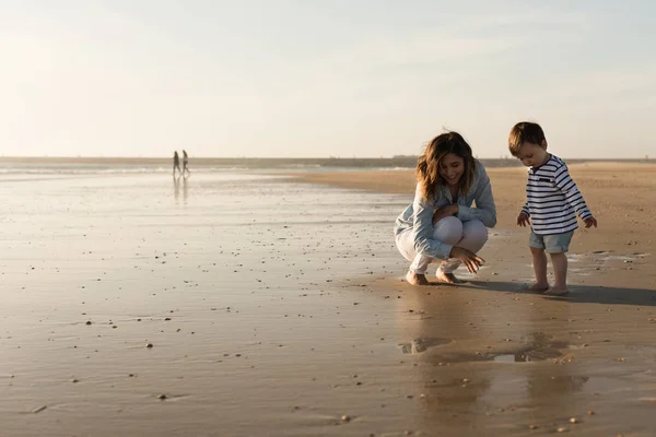 年轻母亲探索海滩与幼儿 — 图库照片