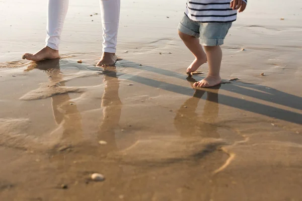 若い母親は幼児とビーチを散策 — ストック写真