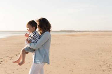 Sahilde yürümeye başlayan çocuk ile keşfetmek Genç Anne