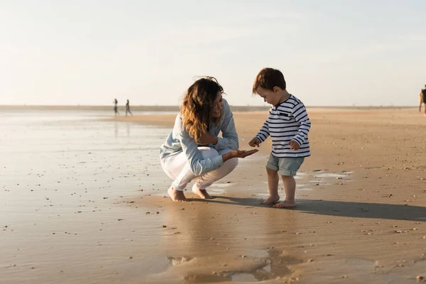 Joven Madre Explorando Playa Con Niño Pequeño —  Fotos de Stock