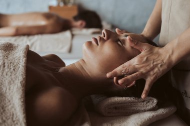 Yüz masajı spa merkezinde olan kadın