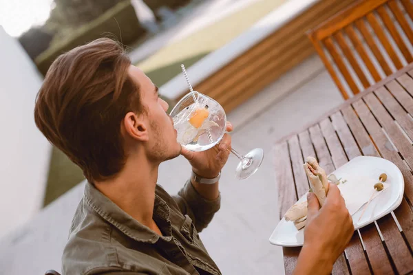 男の飲むカクテルとボーッとしている付近のプール — ストック写真