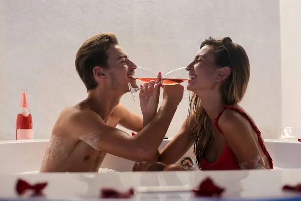 浪漫的年轻夫妇在按摩浴缸里喝香槟 — 图库照片