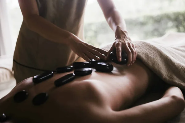 Man Met Een Rug Massage Met Olie Warme Stenen — Stockfoto