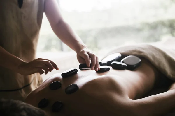 Man Met Een Rug Massage Met Olie Warme Stenen — Stockfoto