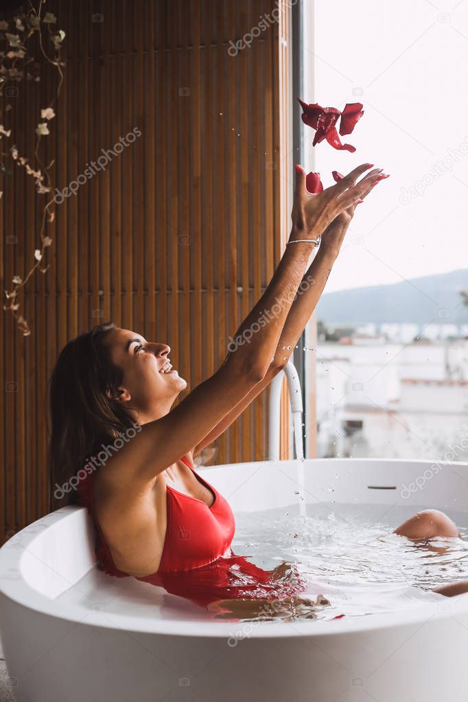 Woman bathing and relaxing in a modern bath tub
