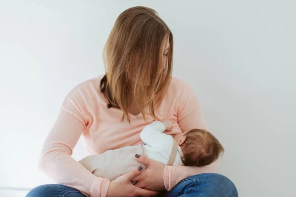 Mãe jovem amamentando bebê recém-nascido — Fotografia de Stock