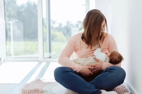 Mãe jovem amamentando bebê recém-nascido — Fotografia de Stock