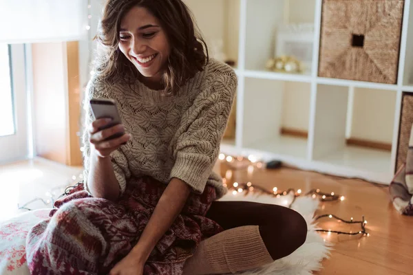 Los mensajes de texto de la mujer en un teléfono inteligente - Temporada de Navidad —  Fotos de Stock