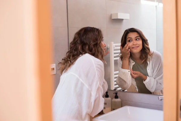 Hermosa mujer en el baño hidratando su piel — Foto de Stock