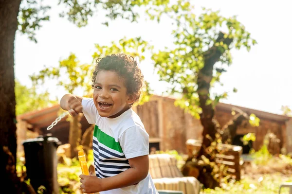 Щасливий Африканський Маленький Хлопчик Грає Мильними Бульбашками Природі — стокове фото