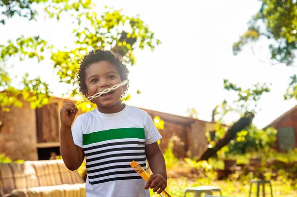 Щасливий Африканський Маленький Хлопчик Грає Мильними Бульбашками Природі — стокове фото