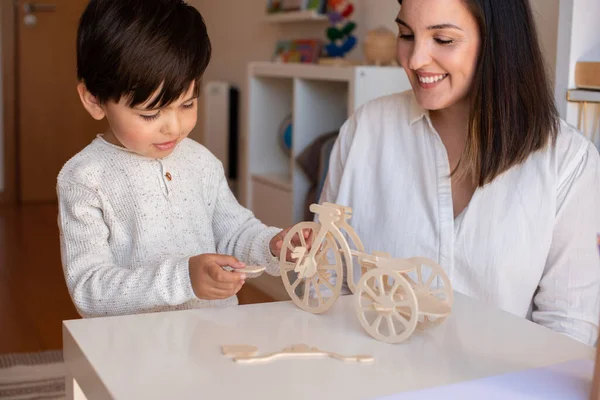 Liltle Preschooler小子玩木头3D拼图和教师教育者的帮助 在家做家务 学习社区 Montessori Schoo — 图库照片