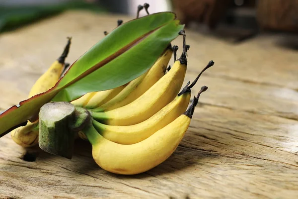 Bananas and leaves placed on old wooden floor.