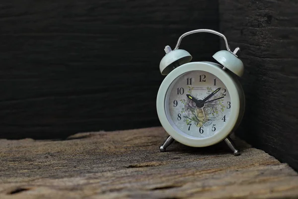 Zegar Umieszczony Starej Drewnianej Podłodze Czarne Tło — Zdjęcie stockowe