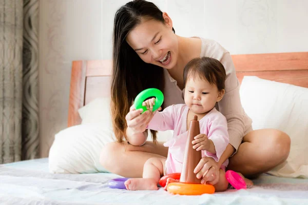 Mãe feliz ensina habilidades de coordenação filha de 2 anos usando brinquedos de aro de plástico — Fotografia de Stock