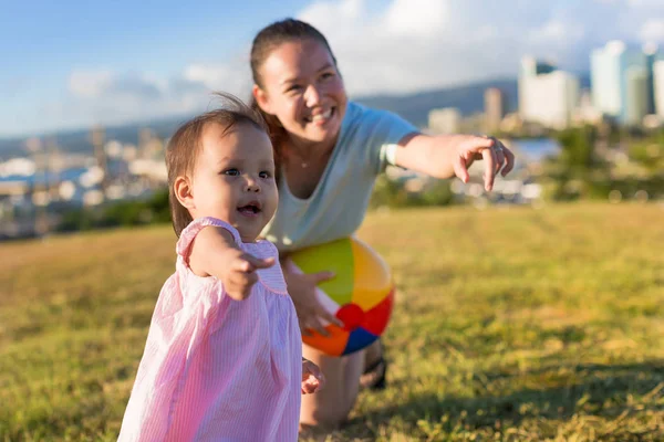 Menina e sua mãe aprendendo a jogar jogos de bola em uma tarde agradável no parque — Fotografia de Stock