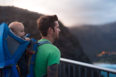Manzaraya bakan bir dağın tepesinde duran bir uyum yürüyüşçisi. Çocuklarla egzersiz yapmak. Seyahat.