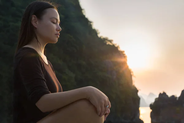 Mujer relajante y meditando en la naturaleza, al atardecer. Zen pacífico . — Foto de Stock