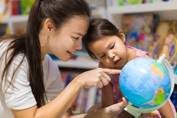 Учитель и дошкольник, изучающий географию на мировом шаре — стоковое фото