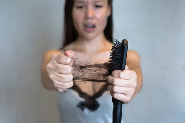 O cabelo de uma mulher a cair. Perda de cabelo . — Fotografia de Stock