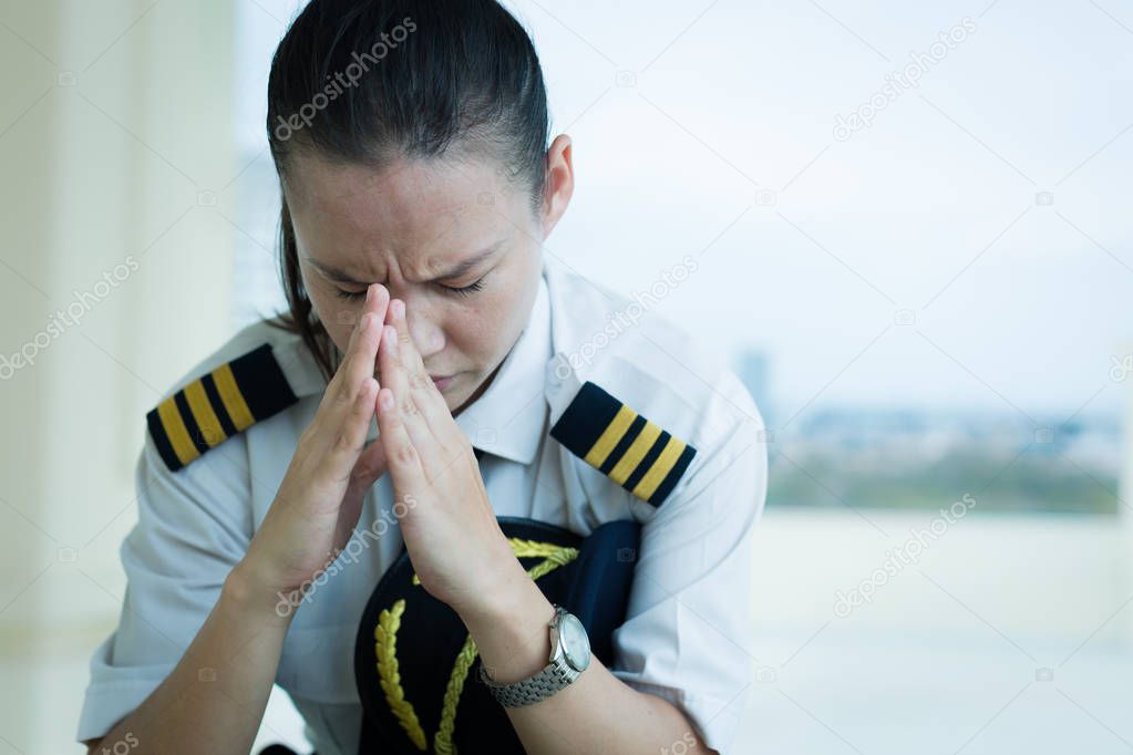 Stressed out female pilot worried at work.