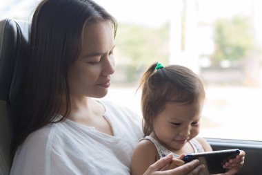 Bir anne ve çocuk trende televizyon izliyor, birlikte seyahat ediyor..
