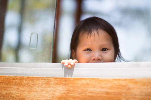 Petit enfant mignon jouant à cache-cache dans le parc . — Photo