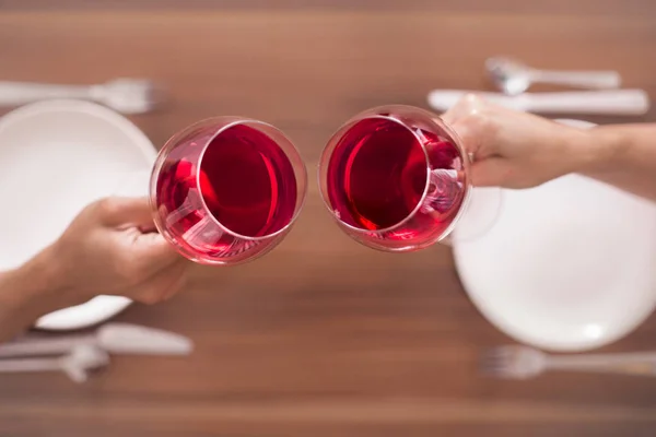 Duas pessoas segurando copos de vinho brindando em um encontro . — Fotografia de Stock