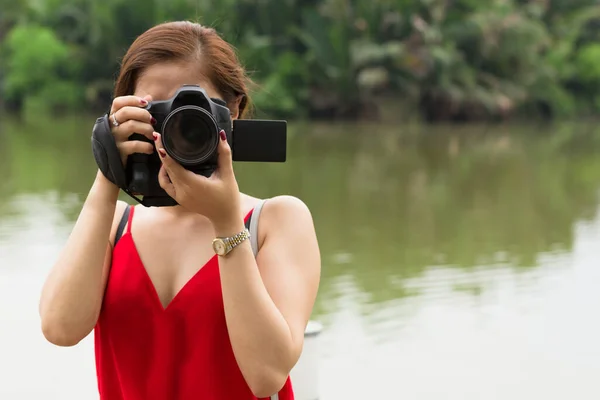 女性は 水の近くに自然の中で カメラを前に直面して写真を撮る 肖像画 — ストック写真